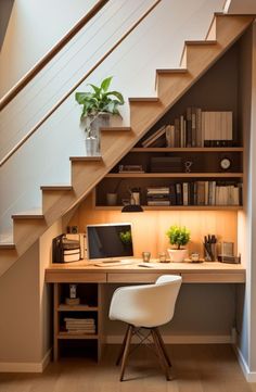 a desk under the stairs with a computer on it