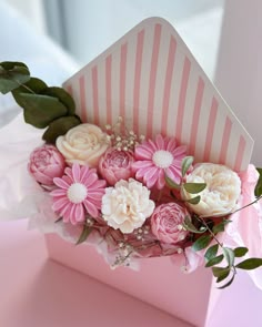 a pink and white box with flowers in it