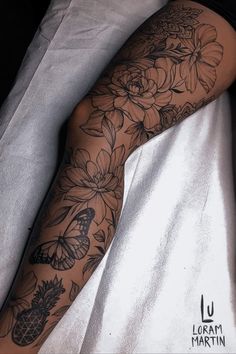 a woman laying on top of a bed next to a white sheet covered in tattoos