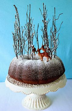 a cake with frosting and deer figurines on top