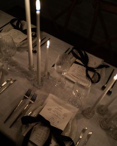 the table is set with silverware, candles and napkins for an elegant dinner