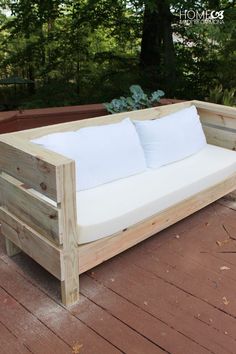 a couch made out of wooden pallets on a deck with yellow poles and pillows