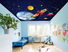 a child's bedroom decorated in blue and white with space themed ceiling tiles on the ceiling