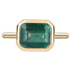 For Sale on 1stDibs - Displayed is a vibrant-green emerald, solitaire, emerald-cut bezel ring in 14K yellow gold. This gorgeous solitaire ring carries a full 3.85-carat emerald Emerald Cut Emerald Ring, Stone Gold Ring, Engagement Ring Emerald Cut, Bezel Set Engagement Ring, Emerald Cut Ring, Engagement Ring Emerald, Ring Emerald Cut, Bezel Engagement Ring, Trilogy Ring