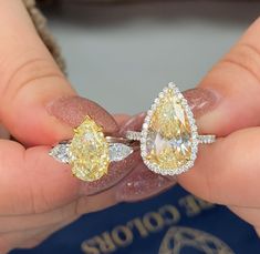 someone holding two yellow and white diamonds in their hands