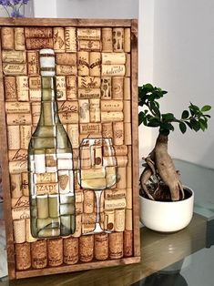 a wine bottle and two glasses on a table with a potted plant in the background