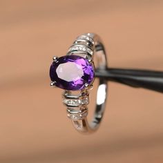 It is a natural amethyst ring. The main stone is 7 mm*9 mm oval cut.weight about 1.77 carats.The basic metal is sterling silver and plated with rhodium.To change the metal to a solid gold (white/rose) or platinum is also available, please ask for a quotation if you want.You can also go to my shop Home for more elegant rings: https://www.etsy.com/shop/godjewelry?ref=hdr_shop_menu Amethyst is the February birthstone More amethyst rings:https://www.etsy.com/shop/godjewelry?section_id=20709248Custom