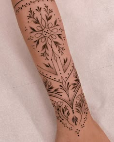 a woman's foot with a tattoo design on the side of her left leg