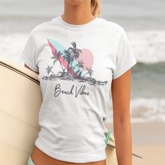 Get into the summer spirit with our Beach Vibes T-shirt featuring a stunning image of a beach, palm trees, and a surfboard. This graphic tee is perfect for those who love the ocean and all things beach-related. Made from high-quality materials, this t-shirt is comfortable to wear and will quickly become a favorite in your wardrobe. Whether you're planning a trip to the coast or just want to bring some beach vibes into your daily life, this shirt is the perfect choice. Makes a great gift for beach lovers and anyone who enjoys a touch of tropical paradise in their outfits. Order yours today and let the summer vibes wash over you! .: 100% Airlume combed and ringspun cotton (fiber content may vary for different colors) .: Light fabric (4.2 oz/yd² (142 g/m .: Retail fit .: Tear away label .: Ru Graphic Print T-shirt For Summer Vacation, Tropical Graphic Print T-shirt For Beach, Tropical Graphic Print T-shirt For Vacation, White Tropical Print T-shirt For Summer, Hawaiian T-shirt For Surfing And Beach Season, White Tropical Print T-shirt For Vacation, White Tropical T-shirt For Beach Season, Tropical Print T-shirt For Vacation, Tropical Print Short Sleeve T-shirt For Vacation