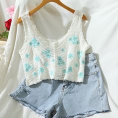 a pair of shorts and a crop top on a white bed with flowers in the background