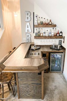 a bar with stools and shelves filled with bottles on top of it, next to a window