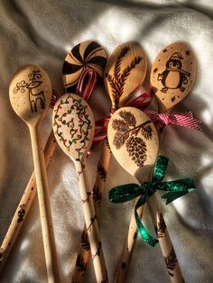 six wooden spoons with designs on them are lined up in a row and tied together