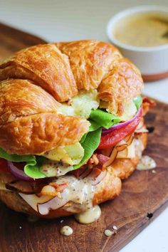 a croissant sandwich with lettuce, tomato, and cheese on it