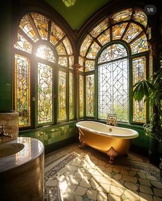 an ornate bathroom with stained glass windows and a claw foot bathtub in the center