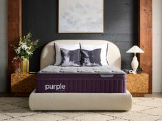 a purple mattress sitting on top of a bed in a bedroom next to a lamp