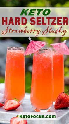 three glasses filled with strawberry slushy next to strawberries on a metal tray