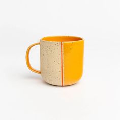 an orange and white coffee cup sitting on top of a table