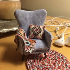 a blue chair with a colorful pillow on top of it