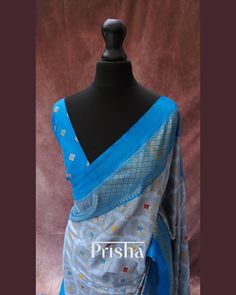 This grey saree features bandhani print on Pashmina silk, accented by a striking blue contrast border. Expertly crafted using the perfected hand block printing technique, the border of the saree narrates the timeless stories of rural villagers from centuries past. The saree is completed with elegant blue tassels. Blouse: Blue bandhani printed Pashmina silk [unstitched] Please note, slight color variations may occur due to lighting. please send us a message if you want blouse material separated Blue Tussar Silk Pre-draped Saree With Dupatta, Transitional Blue Silk Pre-draped Saree, Blue Jamawar Pre-draped Saree With Zari Weaving, Blue Tussar Silk Dupatta With Printed Border, Blue Silk Traditional Wear With Printed Border, Blue Bollywood Tussar Silk Pre-draped Saree, Blue Fusion Style Dupatta With Traditional Drape, Blue Tussar Silk Pre-draped Saree, Festival Blue Tussar Silk Pre-draped Saree