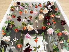 an arrangement of artificial flowers hanging from the ceiling