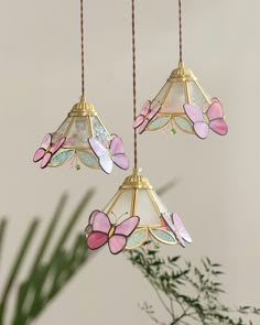 three hanging lights with pink butterflies on them