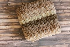 a crocheted blanket sitting on top of a wooden floor