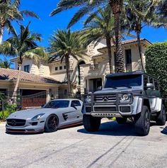 two mercedes benzs parked next to each other in front of a house with palm trees