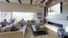 a living room filled with furniture and a flat screen tv mounted on the wall over a fireplace