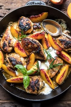 a skillet filled with chicken and peaches