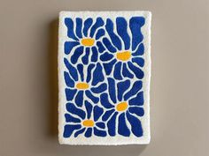 a blue and yellow flowered design on a white towel hanging from a hook rack