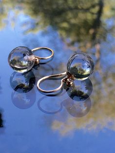 "Little POOLS OF LIGHT Dangle Earrings 12mm Round Clear Genuine Rock Crystal Quartz Drops / 14K Gold Filled Bead Caps Hand forged 14K Gold Filled NICKEL FREE* Ear Wires LARGER 14mm Version of the same earrings: https://www.etsy.com/listing/1075602186/floating-pools-of-light-14mm-genuine?ref=shop_home_active_1&frs=1&sca=1 CHECK OUT THE MATCHING ORB PENDANT NECKLACE: https://www.etsy.com/listing/654718365/pools-of-light-14mm-rock-crystal-quartz?ref=shop_home_active_1 *ALL METAL I USE ON AN Formal Clear Round Beaded Jewelry, Handmade Elegant Spherical Jewelry, Clear Round Wedding Earrings, Hypoallergenic Round Bead Jewelry For Formal Occasions, Formal Hypoallergenic Jewelry With Round Beads, Hypoallergenic Formal Jewelry With Round Beads, Formal Jewelry With Matching Spherical Earrings, Hypoallergenic Clear Jewelry For Wedding, Hypoallergenic Round Clear Jewelry