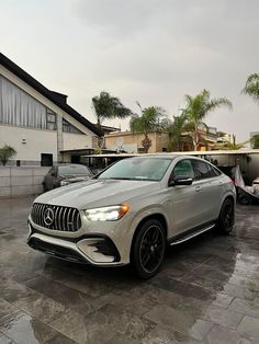 a white mercedes suv parked in front of a house