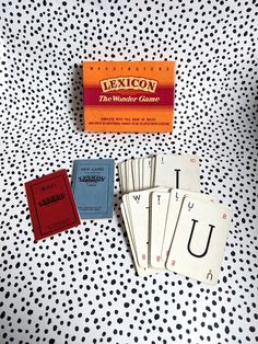 a table topped with lots of cards on top of a polka dot covered surface next to an orange box