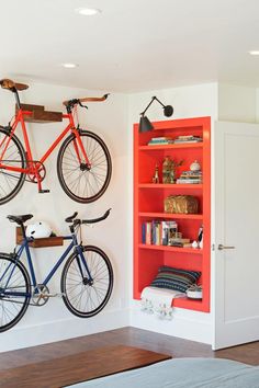 there are two bikes mounted to the wall in this room with bookshelves and shelves