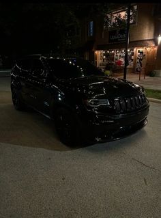 a black jeep parked in front of a store at night