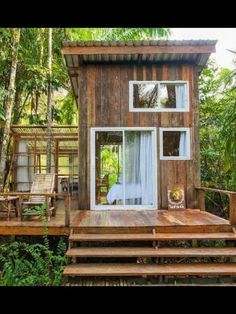 the tiny house is built on stilts in the woods with stairs leading up to it