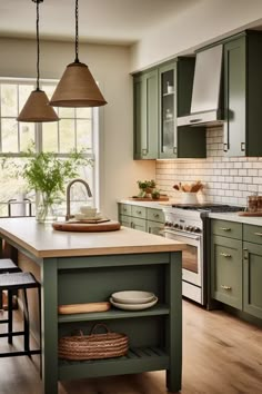 a kitchen with green cabinets and an island in front of the stove, sink and oven