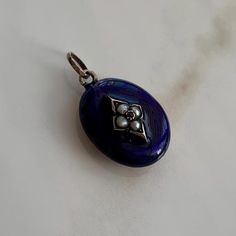 An antique mourning gold gilded locket, blue enamel, and set garnet and Pearl pendant.  CONDITION: Good condition. Wear consistent with age and use. Please see photos for more detail. BROOCH SIZE: 19mm x 14mm DIAMOND SHAPE SETTING SIZE: 7mm x 10mm PENDANT LENGTH INC. LOOP: 25mm WEIGHT: 3.9 grams PEARL SIZE: 2mm GARNET SIZE: 1mm LOCKET WINDOW SIZE: 15mm x 12mm Antique Evening Locket Jewelry, Antique Oval Pendant Locket Necklace For Memorials, Handmade Antique Oval Locket Necklace, Historical Collectible Locket Jewelry, Antique Enamel Locket Necklace, Memory Locket, Window Sizes, Gold Gilding, Pearl Size