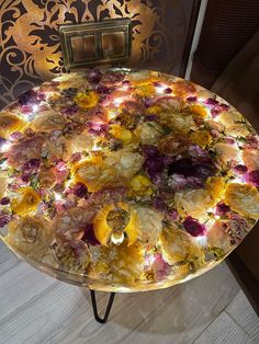 a table that has flowers on it with lights in the middle and an ornate wall behind it