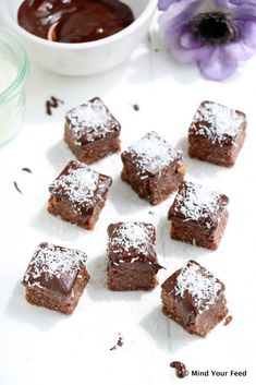 chocolate brownies with powdered sugar on top and a bowl of cocoa in the background