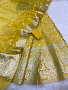 It's a beautiful lehenga set of chanderi material . The whole collection has beautiful pastel and few bright shades .  Lehenga - 5 Mtr Banarasi Matt zari lorex fabric. Blouse - 1 mtr lorex matt zari Dupatta - 2.5 mtr matt lorex fancy weaving  Dry clean only . Please note - color may be vary a little due to sunlight and photography . This is unstitched material only . Lehenga and blouse stitching is also available . Unstitched Gold Cotton Silk Anarkali Set, Gold Cotton Silk Unstitched Anarkali Set, Designer Cotton Silk Lehenga With Sheer Dupatta, Gold Semi-stitched Anarkali Set In Cotton Silk, Gold Cotton Silk Sharara With Dupatta, Festive Sheer Dupatta Cotton Silk Lehenga, Gold Cotton Silk Sharara With Cutdana Details, Designer Yellow Cotton Silk Set, Elegant Yellow Dola Silk Anarkali Set