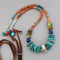 "Various cuts of beautiful American Turquoise, fiery Carnelian, midnight blue Lapis Lazuli and handmade fine silver beads are wrapped to tiny hammered silver circles and brown leather cord. Turquoise, Lapis and Coral beads drop from the circles. It adjusts with a silver slide to any length up to approx. 36\". It's signed DJStrang. All metal is solid .970 fine silver and .925 sterling silver. Turquoise - approx. 3 to 15mm Carnelian - approx. 5mm Lapis - 4 -8mm Length - adjustable to any length up Hand-strung Turquoise Jewelry For Festivals, Blue Gemstone Jewelry For Festivals, Traditional Blue Turquoise Gemstone Necklace, Blue Gemstone Beads Jewelry For Festivals, Blue Turquoise Necklace For Festivals, Bohemian Blue Turquoise Necklace With Natural Stones, Bohemian Blue Beaded Necklace For Festivals, Artisan Blue Beaded Necklaces For Festivals, Bohemian Blue Beaded Necklaces With Natural Stones