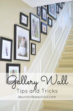 stairs with pictures on the wall above them and below it is a white stair case