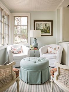 a living room filled with white furniture and lots of window sill space next to a painting on the wall