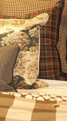 the pillows on the bed are made with different patterns and colors, including deers