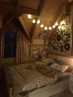 a bed with lots of pillows on top of it in a room filled with pictures