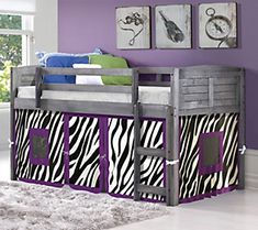 a loft bed with purple and zebra print curtains