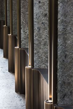 a row of metal poles in front of a wall with marble walls and flooring