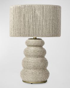 a white lamp with a beige shade on it