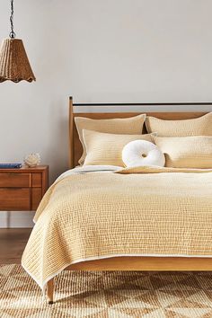 a bed with two pillows on top of it in a bedroom next to a dresser